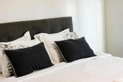 a bed with black and white pillows on it at Alexandra Family Estate in Samoranovo