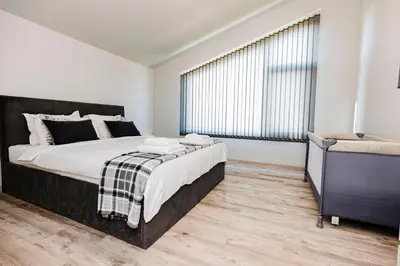 a bedroom with a large bed and a large window at Alexandra Family Estate in Samoranovo