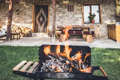 a fire pit in front of a log cabin at Stone house (Каменната къща) in Leshten