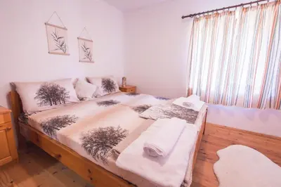 a bedroom with a bed with towels on it at Stone house (Каменната къща) in Leshten