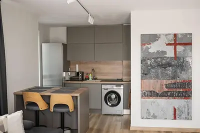 a kitchen with a table and a washing machine at ТОП Апартаменти в Панорама Парк in Plovdiv