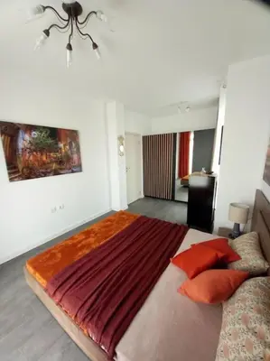 a bedroom with a large bed with red pillows at Luxury Apartment two bedrooms Paul Sеzanne in Hisarya