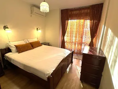 a bedroom with a large bed and a window at VANITY Apartments in Sandanski