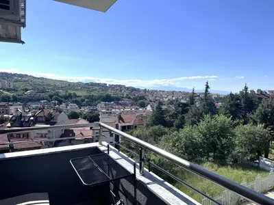 a balcony with a table and a view of a city at VANITY Apartments in Sandanski