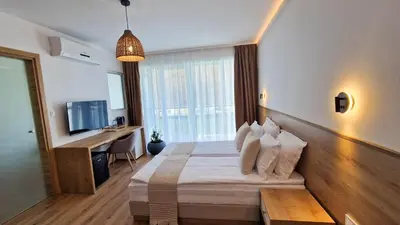 a bedroom with a bed and a desk and a television at Waterside SPA Hotel in Ognyanovo