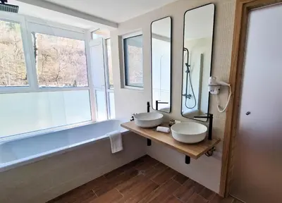 a bathroom with two sinks and a large mirror at Waterside SPA Hotel in Ognyanovo