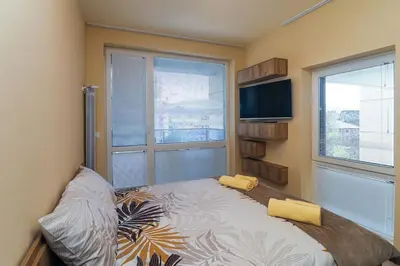 a bedroom with a bed and a tv and a window at Cherkovna Residence Apartment plus GARAGE !!! in Sofia