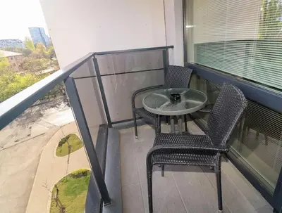 a balcony with a table and chairs and a window at Cherkovna Residence Apartment plus GARAGE !!! in Sofia