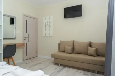 a living room with a couch and a television at ENEVI Guest Houses-Къщи за гости Еневи in Sandanski