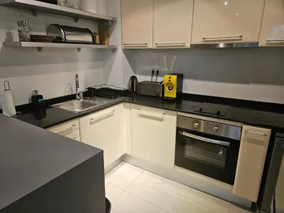 a kitchen with white cabinets and a stove and a sink at TERRA COMPLEX B4 - Private apartment - Golf, Skiing & SPA in Bansko