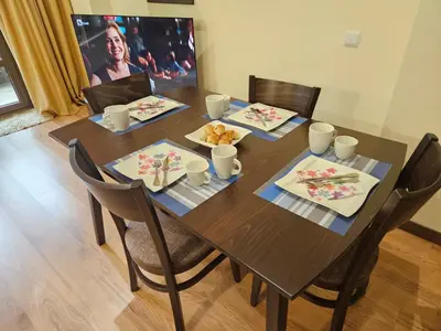 a wooden table with chairs and a table with food on it at TERRA COMPLEX B4 - Private apartment - Golf, Skiing & SPA in Bansko