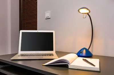 a laptop computer sitting on top of a desk with a book at Central Victoria Home 2-bedroom apt in Plovdiv