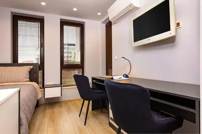 a room with a desk with a bed and a tv at Central Victoria Home 2-bedroom apt in Plovdiv