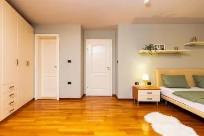 a bedroom with a bed and a wooden floor at La Primavera Spacious Apartment in Plovdiv