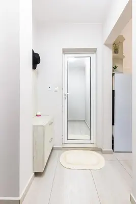 a white bathroom with a mirror and a rug at Studio 'Ozi' quite place in Perfect Center in Plovdiv