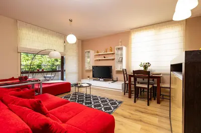 a living room with a red couch and a table at Beautiful apartment in the heart of Plovdiv in Plovdiv