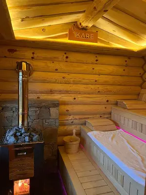 a log cabin with a bed and a stove at Kare Luxury Chalets in Tsigov Chark
