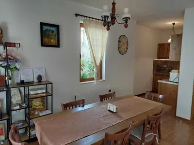 a dining room with a table and a clock on the wall at Villa Victoria in Stoykite