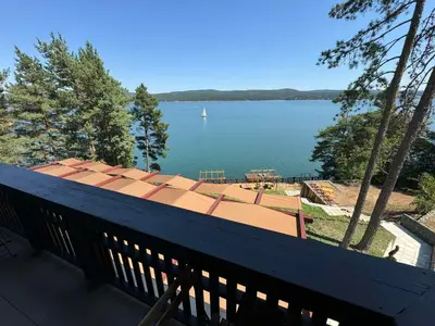 a balcony with a view of a large body of water at Villa Iskar Lake Residence by BookVillaBG in Shtarkelovo Gnezdo