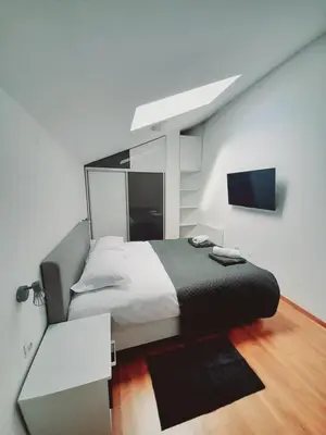a bedroom with a bed and a flat screen tv at lux apartament К602 in Bansko