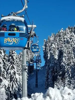a group of people riding a ski lift in the snow at lux apartament К602 in Bansko