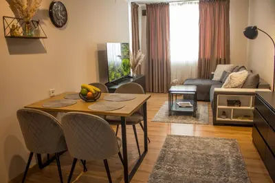 a living room with a table and chairs and a couch at EVIAS Apartment in Sandanski