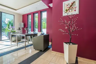 a dining room with purple walls and a table with a tree at Hotel Calipso Hotel in Sofia