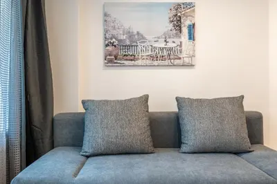 a couch with two pillows in a living room at Harmony Suite in Sofia