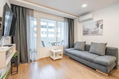 a living room with a couch and a tv at Harmony Suite in Sofia