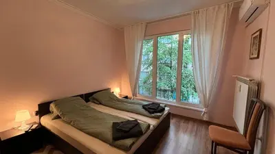 a bedroom with a bed and a large window at Quiet 2 bedrooms downtown apart in Sofia