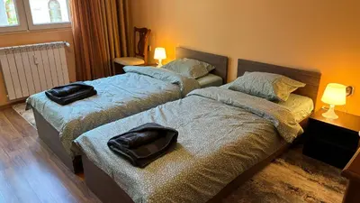 two beds in a small room with two lamps at Quiet 2 bedrooms downtown apart in Sofia