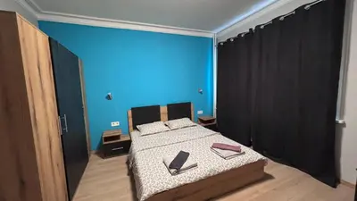 a bedroom with a bed with a blue wall at Garden view top center apart in Sofia