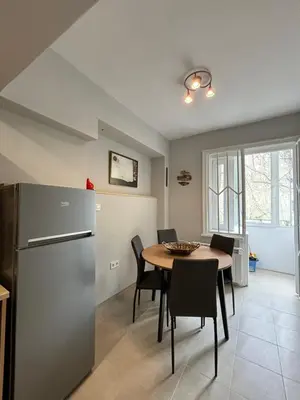 a kitchen and dining room with a table and a refrigerator at Garden view top center apart in Sofia