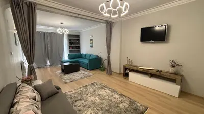 a living room with a blue couch and a tv at Garden view top center apart in Sofia