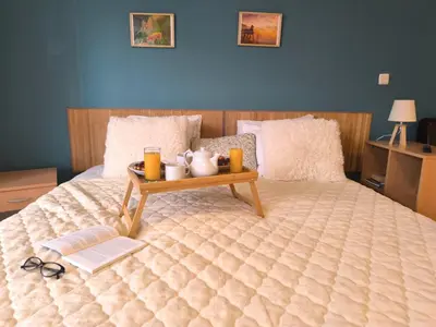 a bed with a tray with a table on it at Cozy nature stay, free Bottle of good Wine, Great view, free Parking in Bansko