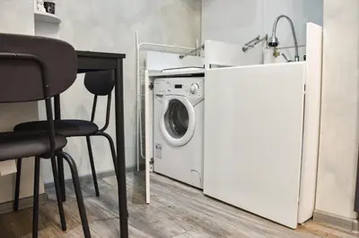 a laundry room with a washing machine and a chair at Tsar Simeon 65 Studio (With Parking space) in Sofia