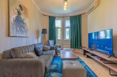 a living room with a couch and a flat screen tv at 2 Designer Apartments Seconds Away From Тhe Main Street, FREE Parking in Sofia