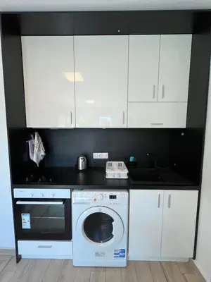a kitchen with white cabinets and a washing machine at Sao Paolo warm and cosy Studio in lively district in Sofia