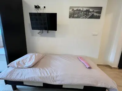 a bedroom with a bed with a flat screen tv on the wall at Sao Paolo warm and cosy Studio in lively district in Sofia