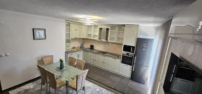 a kitchen with a table and chairs in a room at Д и В 3 - D & V 3 Apartment in Sandanski