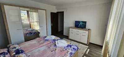 a bedroom with two beds and a television on a dresser at Д и В 3 - D & V 3 Apartment in Sandanski