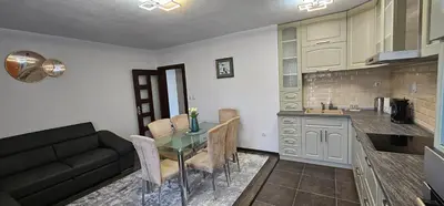 a kitchen and a dining room with a table and a couch at Д и В 3 - D & V 3 Apartment in Sandanski