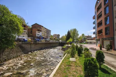 a river in the middle of a city with buildings at Terra apartment in Sandanski