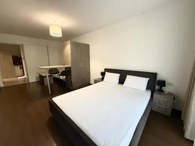 a bedroom with a large bed and a table at Terra apartment in Sandanski