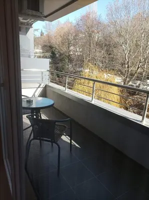 a balcony with a table and a chair and a window at Terra apartment in Sandanski