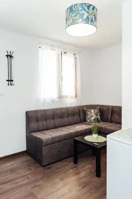 a living room with a brown couch and a table at Къщи за гости БРИК in Sapareva Banya