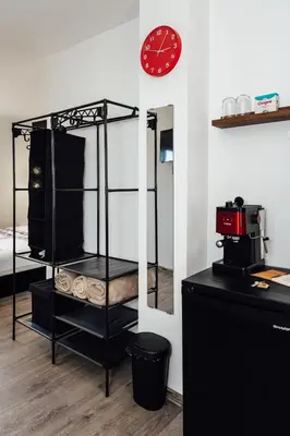 a room with a black shelf and a clock on a wall at Къщи за гости БРИК in Sapareva Banya