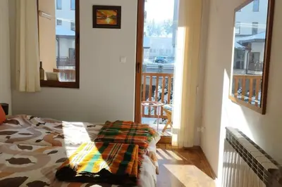 a bedroom with a bed and a view of a balcony at 2BR mountain view, SPA, parking, ski piste in Bansko