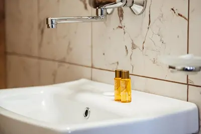 a bottle of yellow soap sitting on a bathroom sink at Къщи за гости БРИК in Sapareva Banya