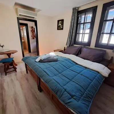 a bedroom with a bed with a blue comforter at Aura house in Dolna Banya